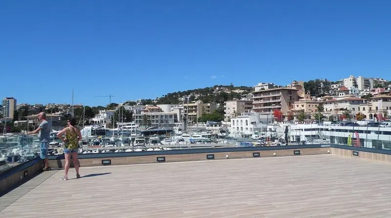 Ashore at Calanova a hardwood terrace looks straight down onto the motor yacht berths, the wooded slope of Palma's western suburbs rising behind the basin.