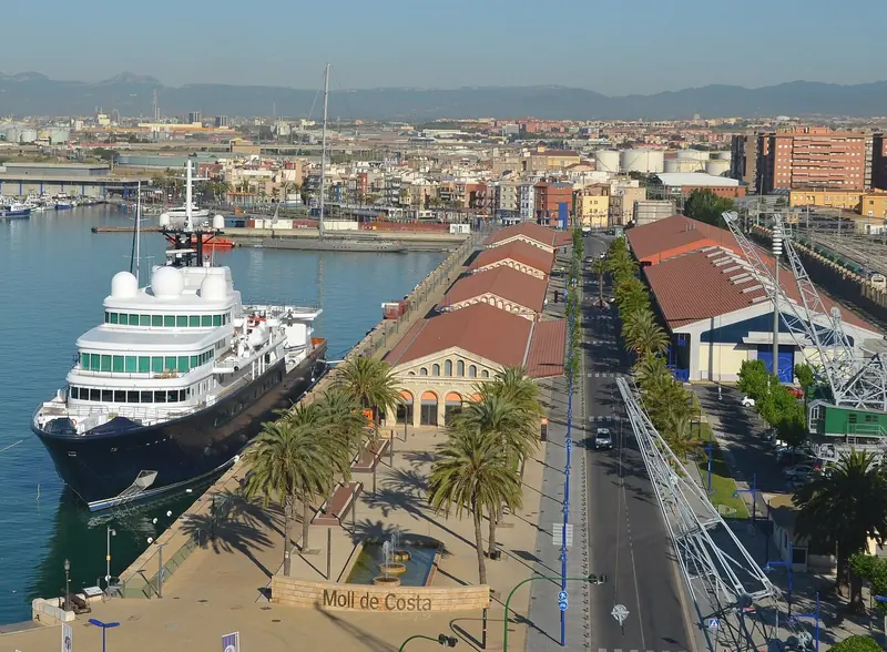 The Moll de Costa from above, a large dark hulled yacht on the wall and the Serrallo quarter of Tarragona behind.