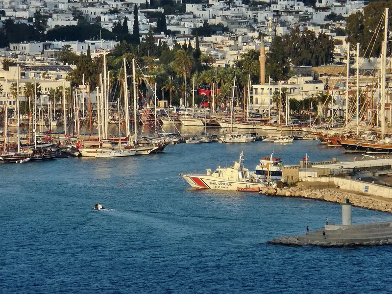 The harbour with the gulet fleet packed along the quay and the coastguard alongside.