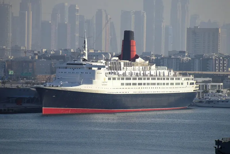 QE2, the former Cunard liner now a floating hotel, docked at Mina Rashid with the Dubai skyline behind her.