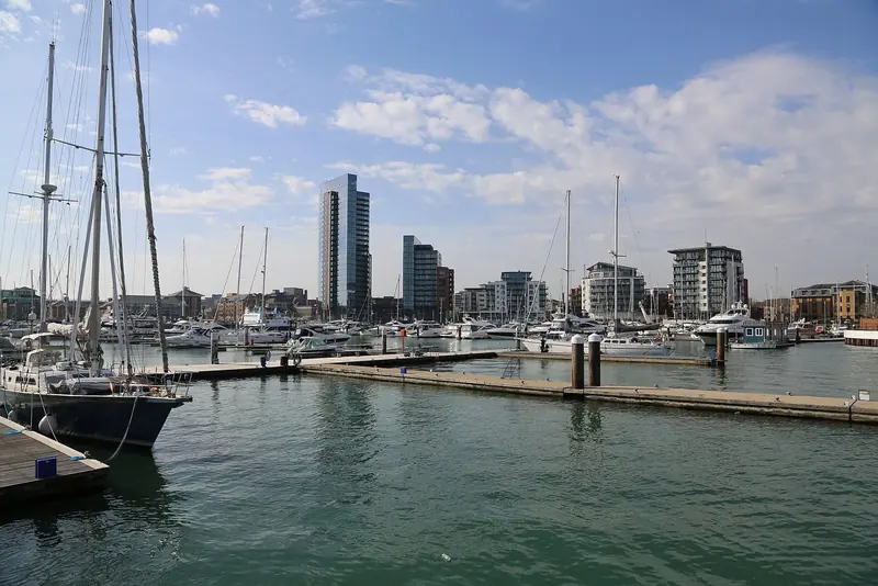 Ocean Village's masts against the towers of the redeveloped waterfront. The marina sits inside a mixed-use quarter, not a stand-alone basin.