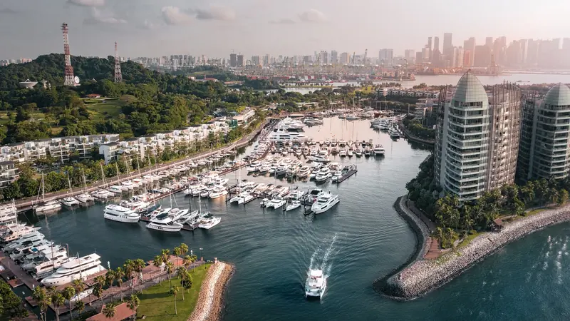 Looking north across the marina toward Singapore's container port and the downtown skyline beyond, the strait that separates Sentosa from the mainland in between.