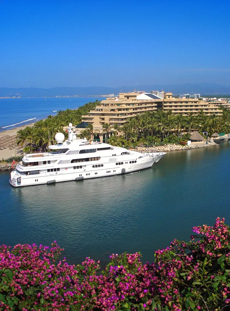 A yacht entering the channel between the resort and the breakwater, the approach every arrival makes past the Paradise Village towers