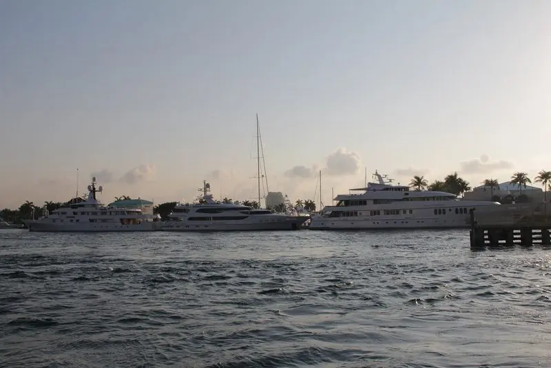 Three big motoryachts sit against the quay on the Intracoastal in the late afternoon, the water flat and the fairway clear behind them.