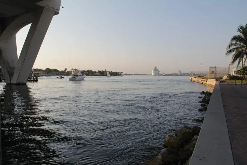 Looking south under the causeway bridge, a sportfisherman runs down the waterway toward the ocean inlet.