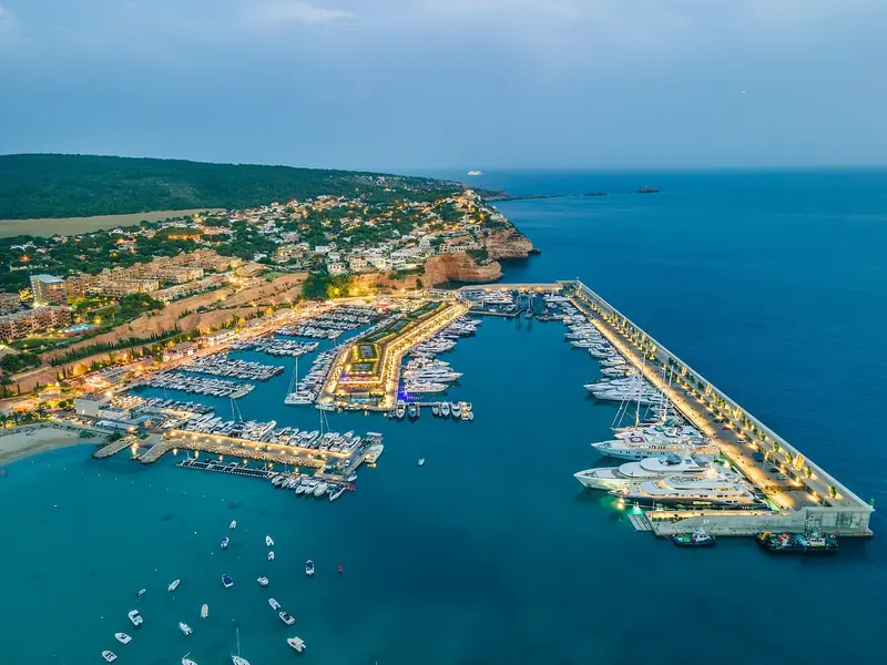 Port Adriano from the air at dusk. The long outer arm is the superyacht quay, which is what the Starck rebuild added to a marina that had none.