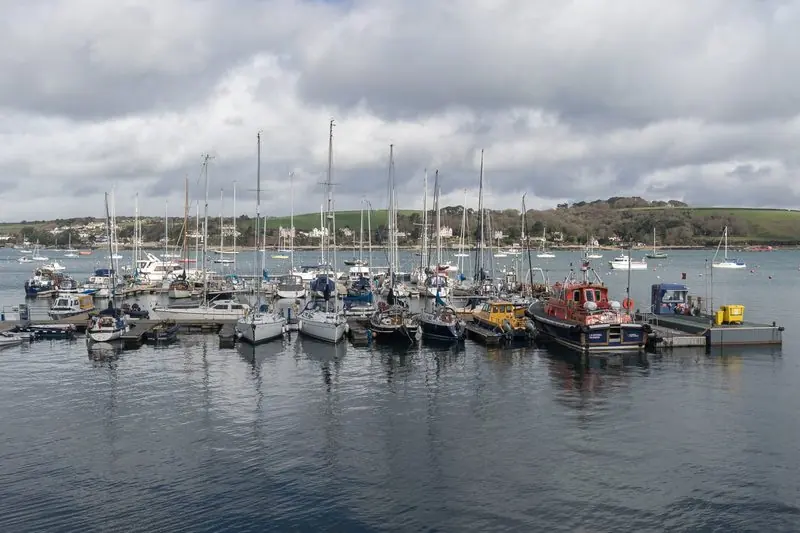 Pontoon berths give straight onto the open water of the Carrick Roads, where moorings run out toward the far shore.