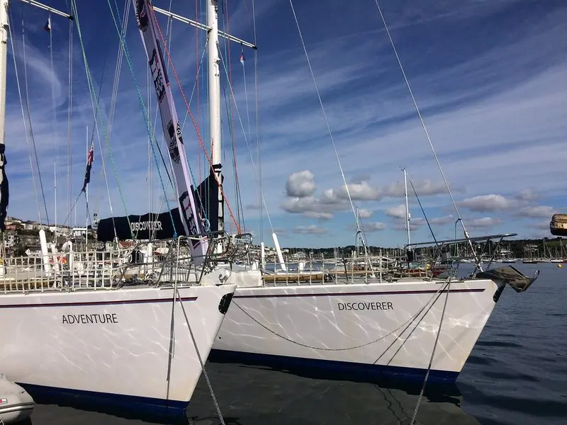 Two heavy ocean going yachts lie rafted alongside the pontoon, rigged and painted for long passages.