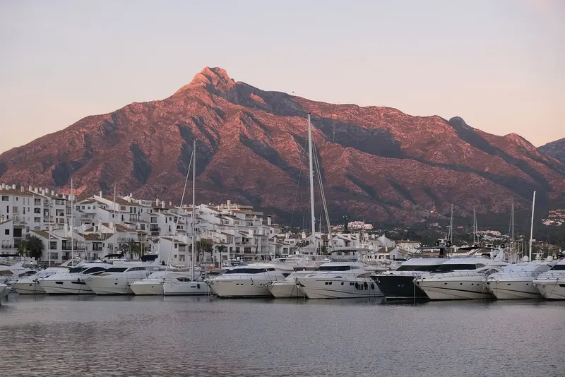 The main quay at last light, the mountain lit behind the fleet.