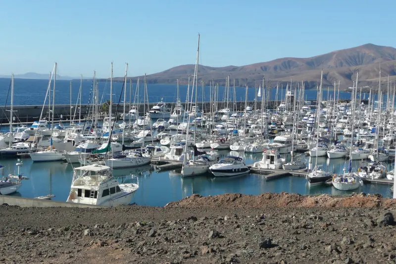 Puerto Calero with the volcanic hills of Lanzarote behind it. The marina was cut into a bare lava coast and everything ashore was built with it.