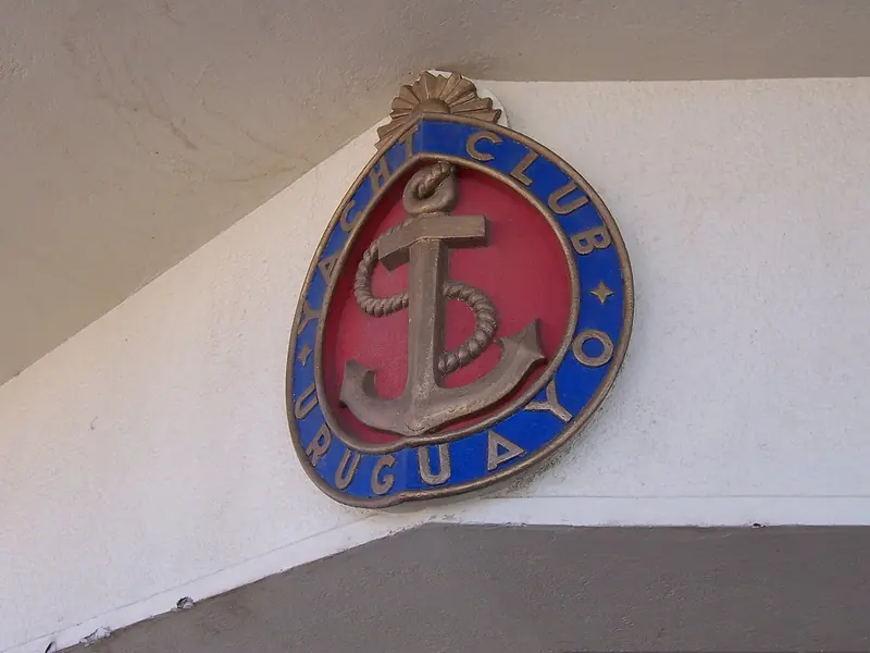 The Yacht Club Uruguayo's own anchor emblem, mounted at the clubhouse entrance.