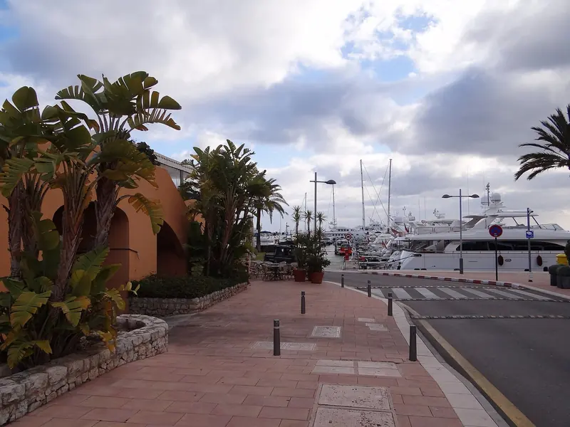 The terracotta arcades that run along the quay at Puerto Portals, with the berths directly in front of them. The shops and restaurants are the marina's business as much as the water is.
