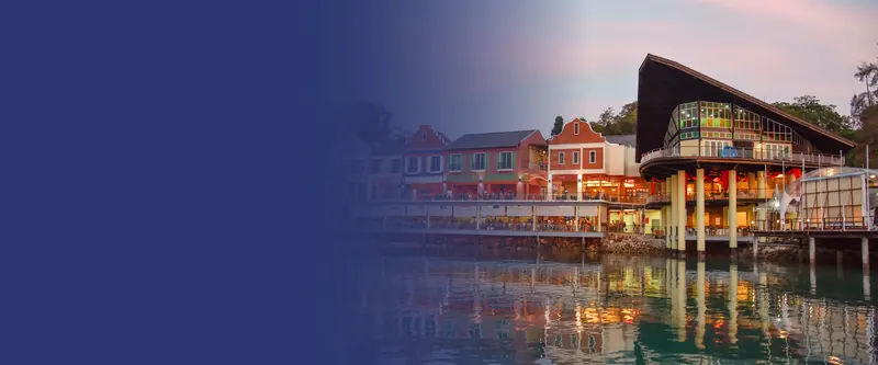 Fisherman's Wharf, the restaurant row built out over the water beside the marina, lit up at dusk.
