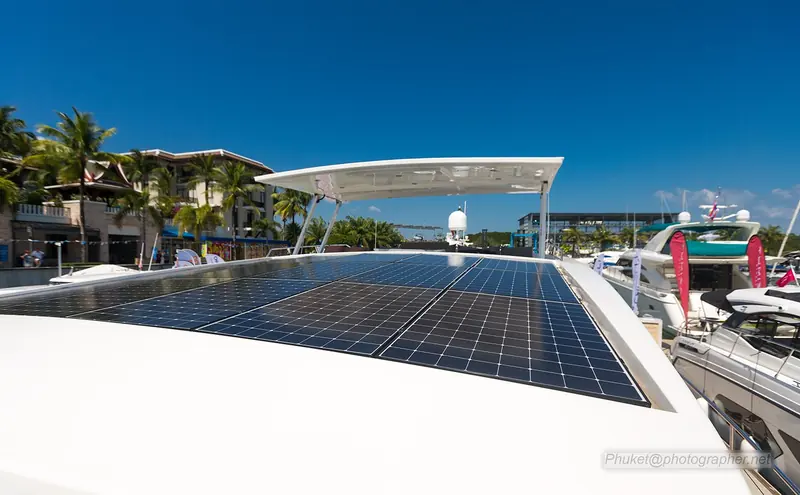 The solar array on a Silent Yacht 55 electric catamaran berthed at Royal Phuket Marina, the marina's shopfronts and moored yachts behind.