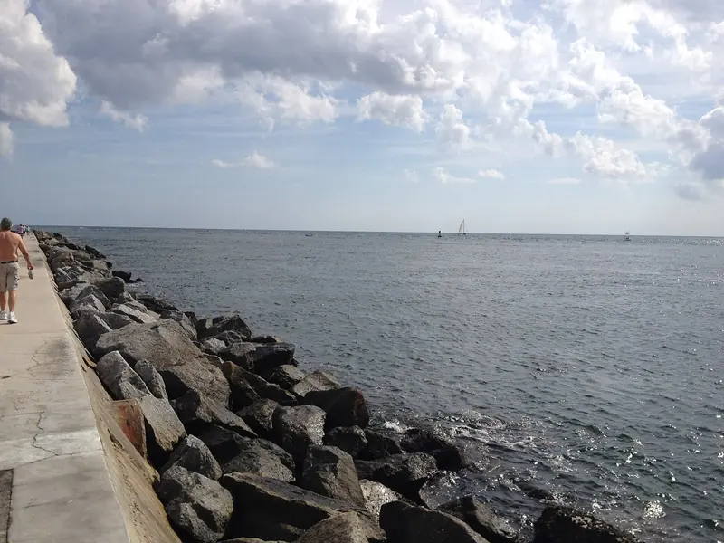 The north jetty at the inlet. The cut is short, it runs hard on an ebb, and a deep-draught hull times it.