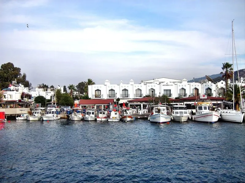 Lit from stem to stern, a large motor yacht rides at anchor off the lights of the town, close enough to run a tender ashore for dinner.