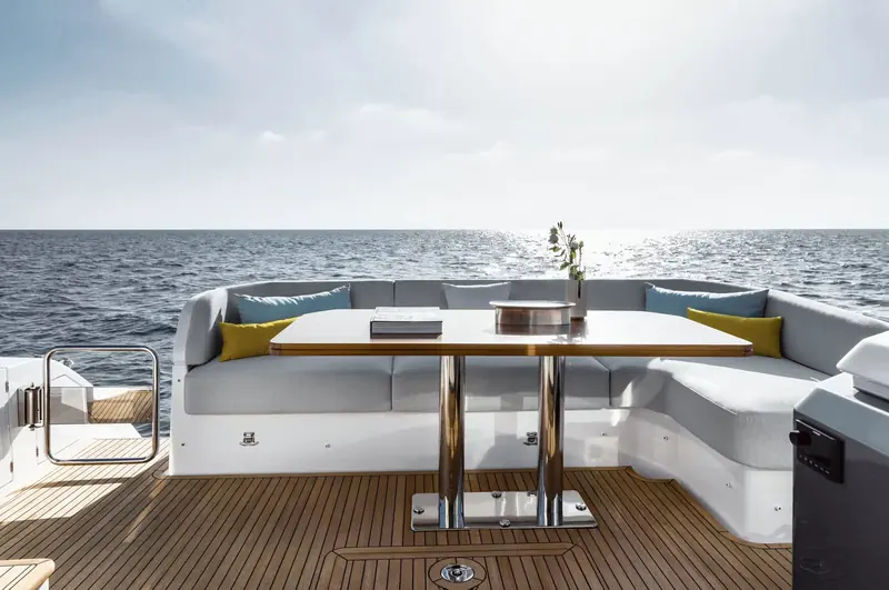 The cockpit opens straight onto the swim platform, with L-shaped seating around a folding table for alfresco dining.