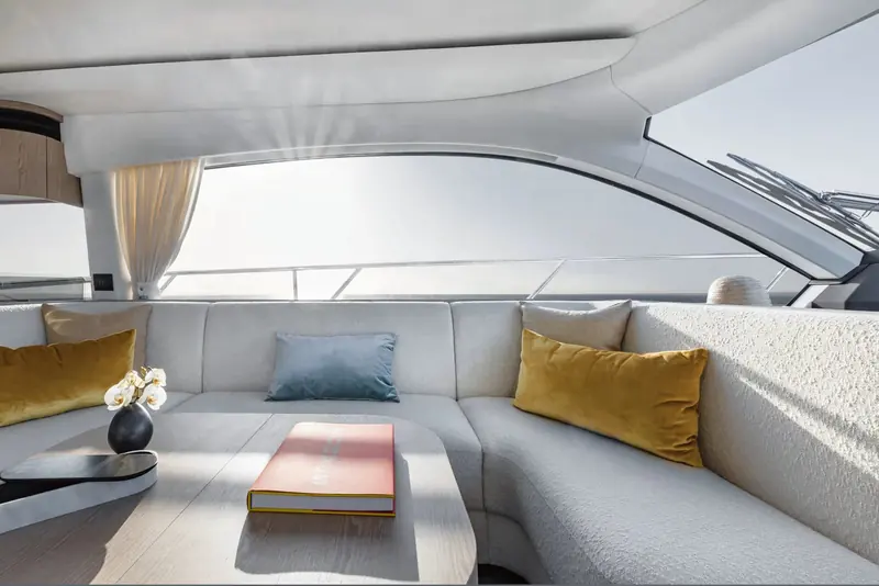 Cockpit dining laid for a meal, shaded by the flybridge overhang above.