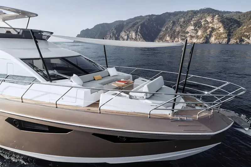 At anchor off Portofino, the flybridge lounge and glazed wheelhouse sit above a deep single-level main deck.