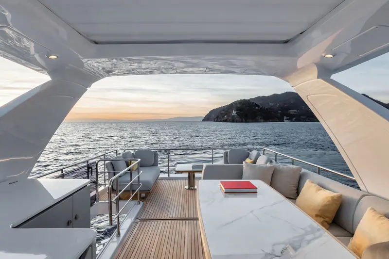 The cockpit opens fully aft to the sea, with a marble-topped table and L-shaped seating for alfresco meals.