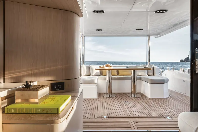 The saloon's wraparound glazing opens the main deck to a bar-height dining table set for lunch.