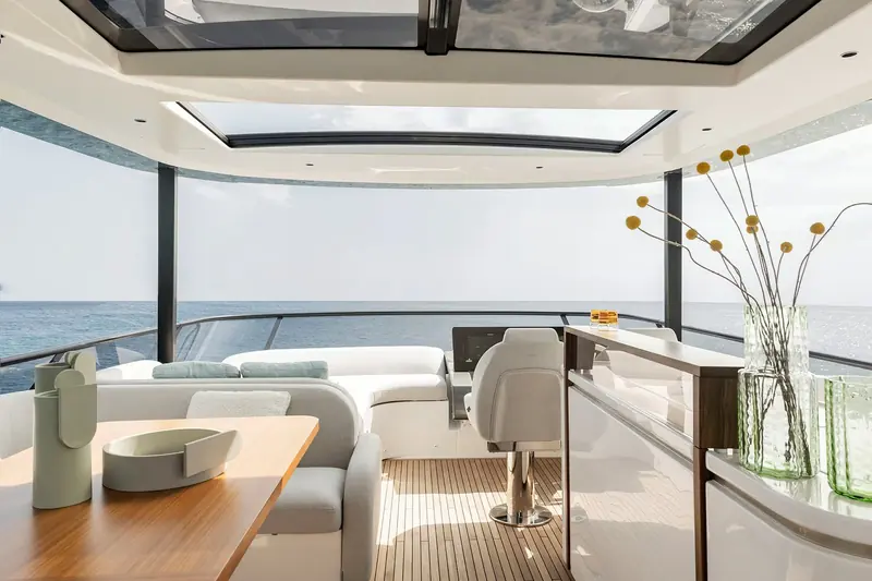 The flybridge helm and wet bar, a fresh vase of dried flowers on the counter and the co-pilot's swivel seat turned to face the view aft.