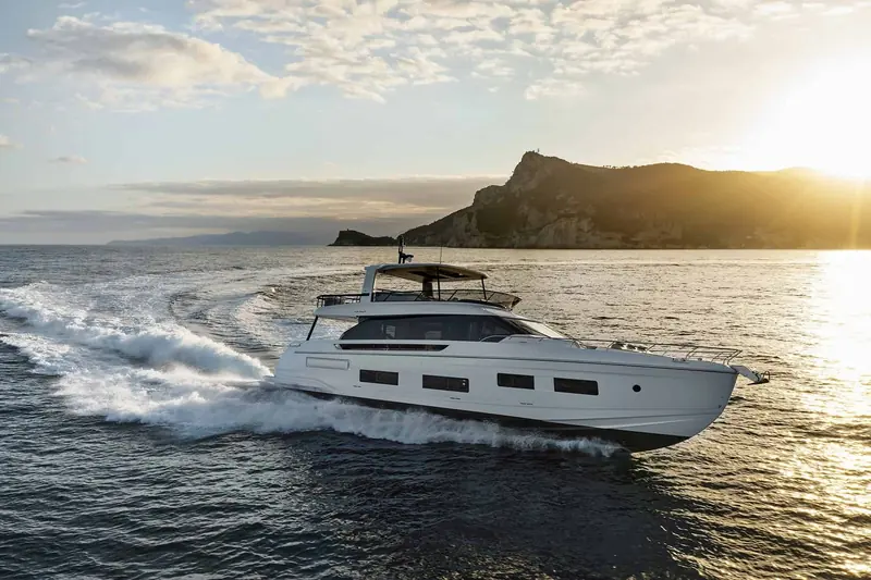 Fly 82 running hard into a Ligurian sunset, the raked hardtop and low sheer line that mark out the current Fly generation silhouette.