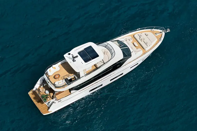 From directly overhead underway, showing the full deck plan at once: flybridge, side decks, cockpit and the private bow lounge forward of the windscreen.