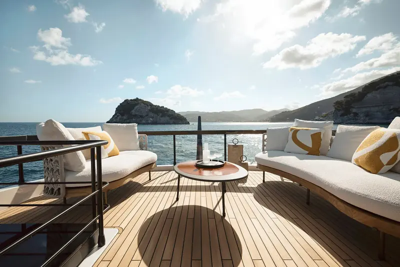 One of the twin curved daybeds on the flybridge sundeck, angled to the view rather than facing inboard.