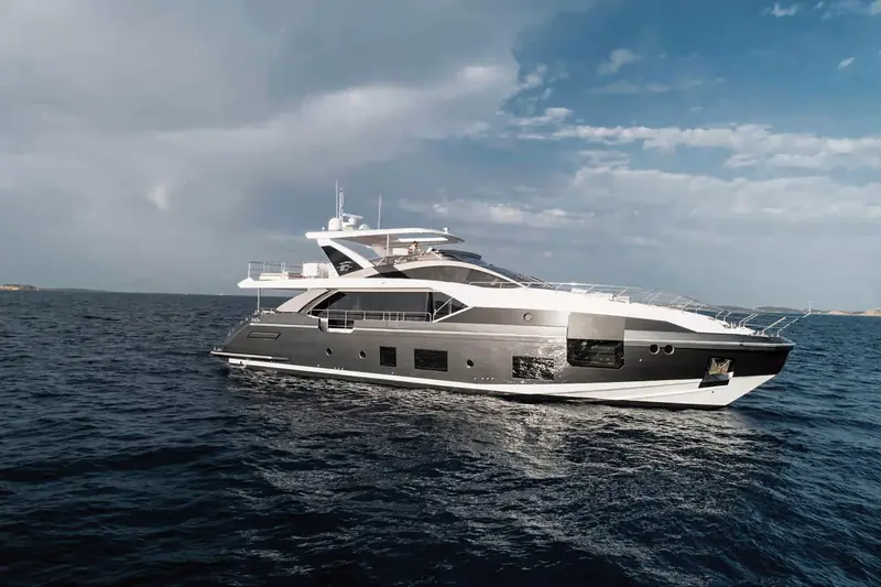 Broadside at anchor under a changing sky, the low, sharp sheer line that distinguishes the Grande series from Azimut's rounder-hulled ranges.