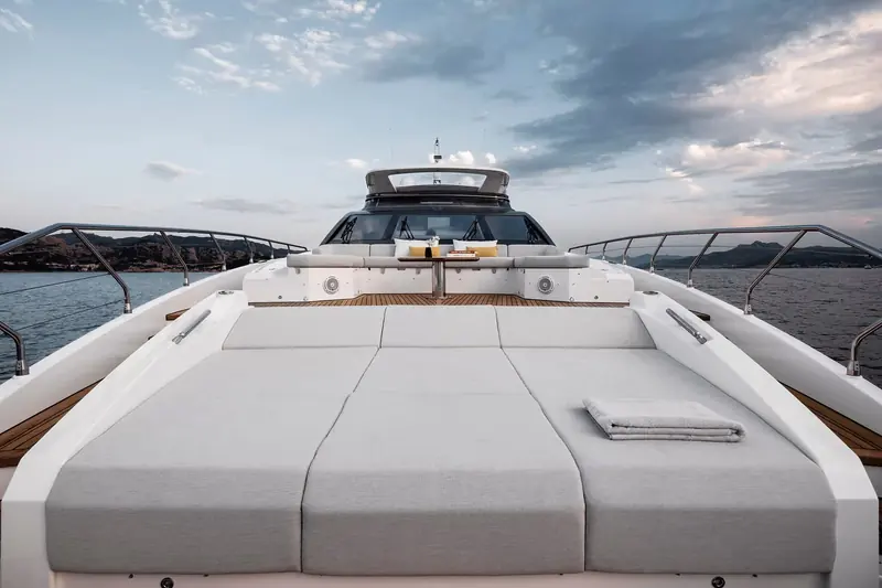The foredeck sunpad, sized for several people and shaped to the bow rather than a simple rectangular cushion.