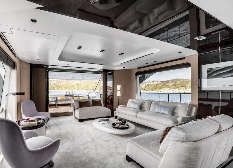 The main saloon, full-height windows on both sides keeping the space bright even with the flybridge overhead.