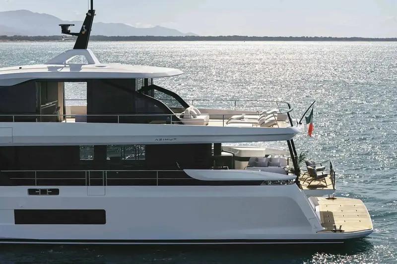 The flybridge carries its own aft lounge and helm station, with a full-width foredeck sunpad forward of it.