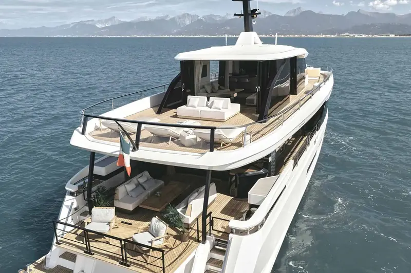 Looking aft from the flybridge sunpad down to the cockpit lounge, sheltered by the deck above.