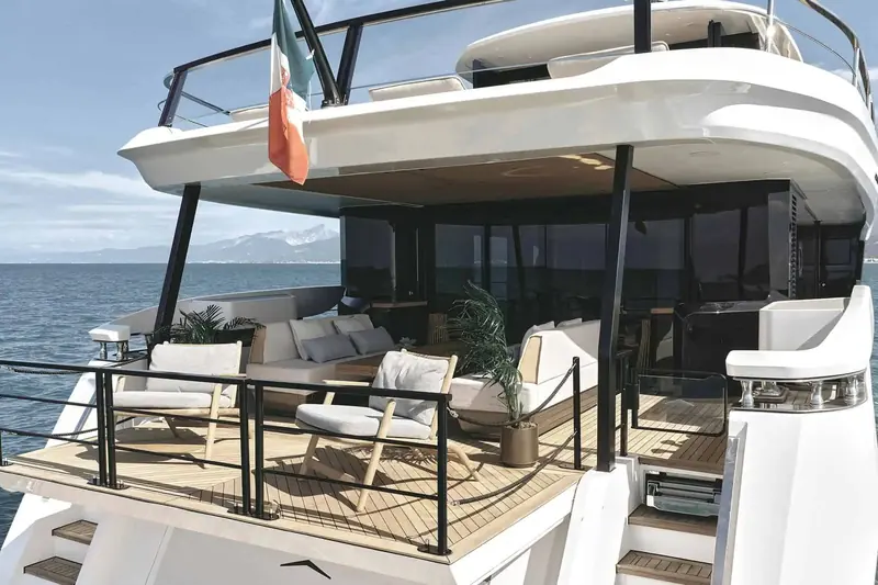 Foredeck seating shaded by the flybridge overhang, with the Italian flag flying from the radar arch.