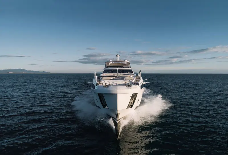 Bow-on in open water, showing the low, wide flare of the hull that keeps spray off the foredeck at speed.