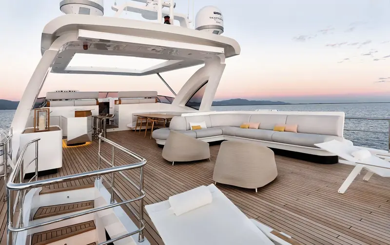 The flybridge, open to the sky beneath its hardtop, laid out for lounging rather than a second helm station.