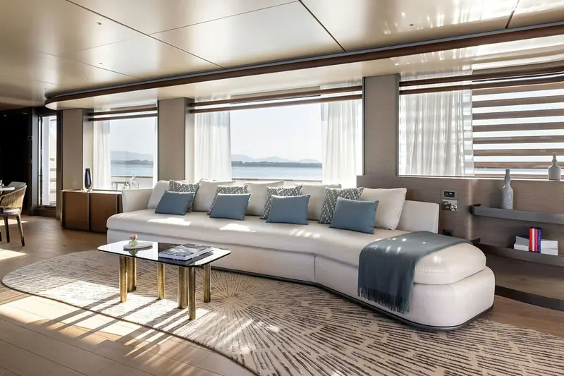 The saloon, a curved sofa and full-height windows on both sides that keep sightlines open to the water while under way.