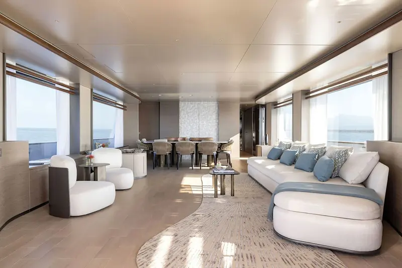 The saloon looking aft to the dining table, seating for the full guest count without folding out a second table.