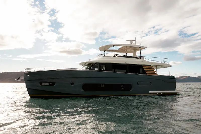 The Magellano 66 at rest under a heavy sky, the dark full-displacement hull and stepped flybridge profile that mark out Azimut's long-range crossover line from its planing boats.