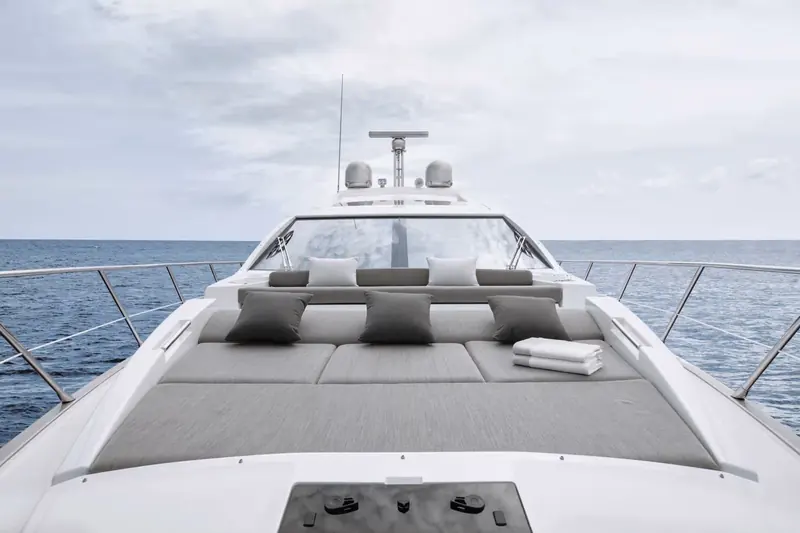 Looking aft from the bow over the forward sunpad and stainless bow rail, with the sportfly console visible above the windscreen.