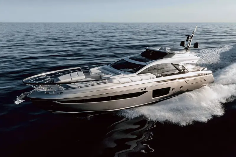 The S8 at speed off a flat Mediterranean afternoon, twin white wakes peeling from the hull and the sportfly helm seating visible open to the sky above the enclosed lower helm.