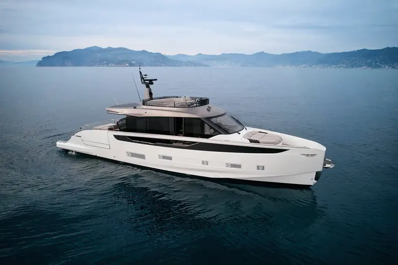 Seadeck 7 at anchor off the Ligurian coast, the low, uninterrupted sheer line and full-beam glazing that set the Seadeck line apart from a conventional flybridge.