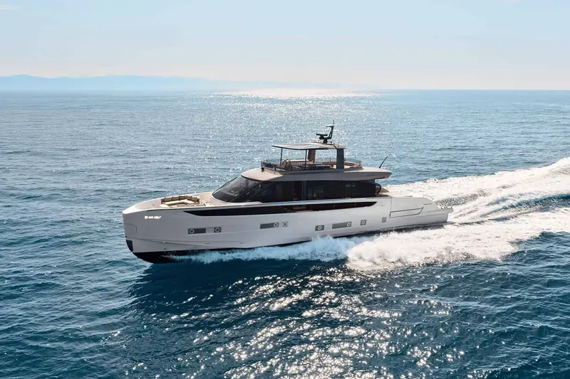 The Seadeck 9 underway off the Italian coast, bow wave breaking clean at the stem. Alberto Mancini drew the exterior over a hull developed with the studio Names.