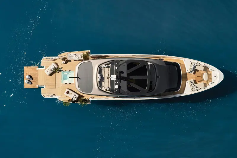 Looking straight down on the aft deck: a stepped pool terrace, twin fold-down side platforms and loaded tenders either side of the flybridge hardtop.
