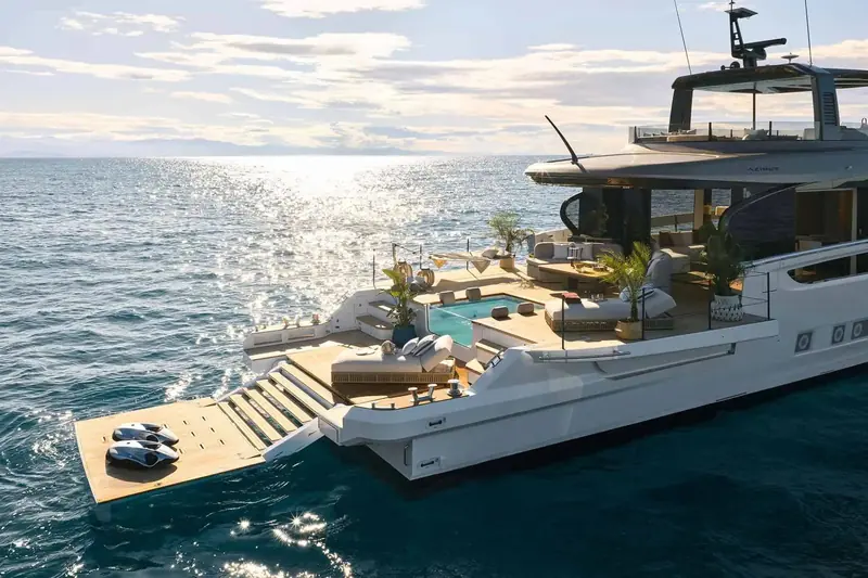 At rest with the side terraces folded out, widening the boat the moment she stops moving and turning the transom into a beach club.