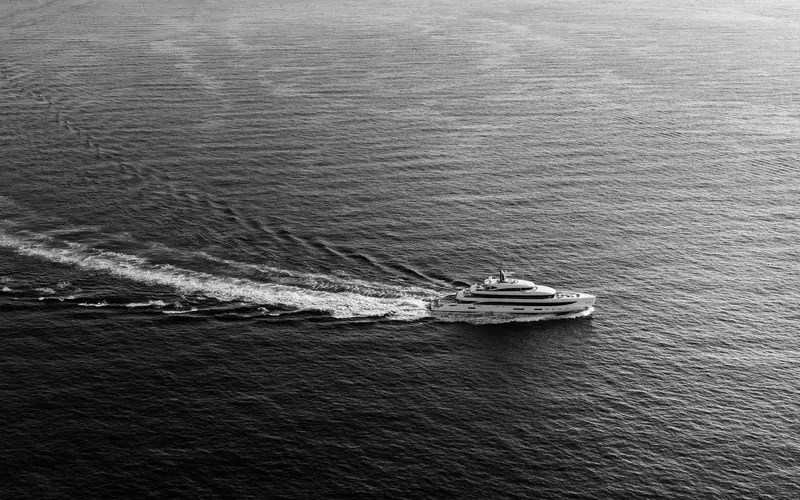 The B.Now 67M carving a wake at speed, shot in black and white against open water.