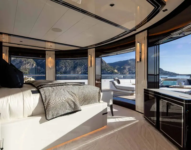 A curved corner cabin with wraparound glazing looking out over a rocky coastline.