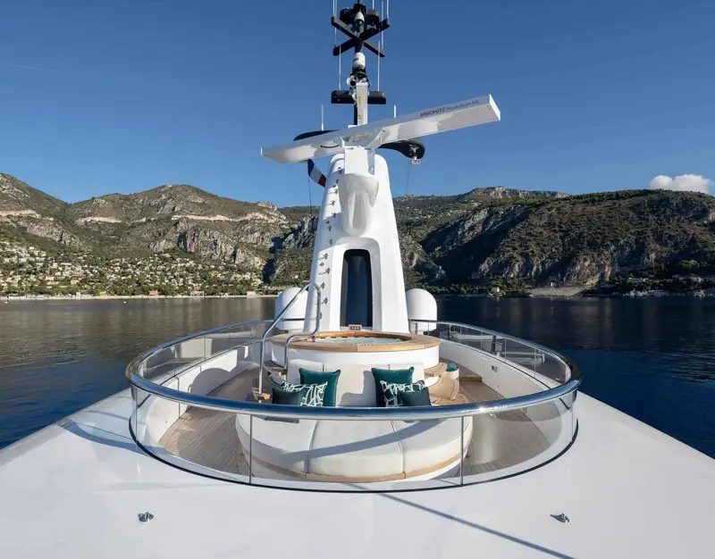 The circular observation deck at the mast, cushioned bench seating with a coastal backdrop.