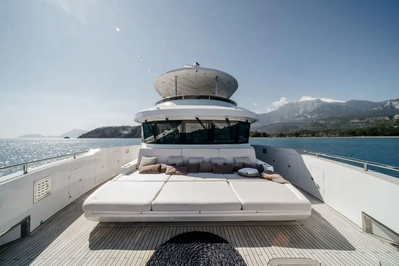 The foredeck lounge seen from the pilothouse, with snow still on the mountains behind the bay.